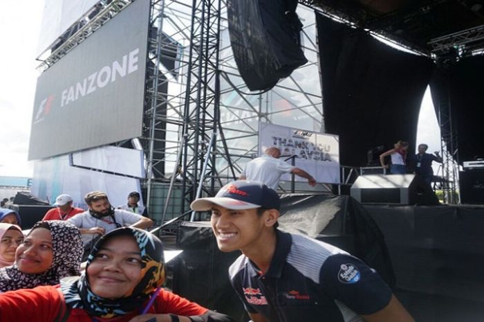 Sean Gelael (memaki topi) menanggapi dengan ramah para penggemar yang ingin berswafoto dengannya pada saat sesi jumpa fan di Sirkuit Sepang, Sabtu (30/9/2017).