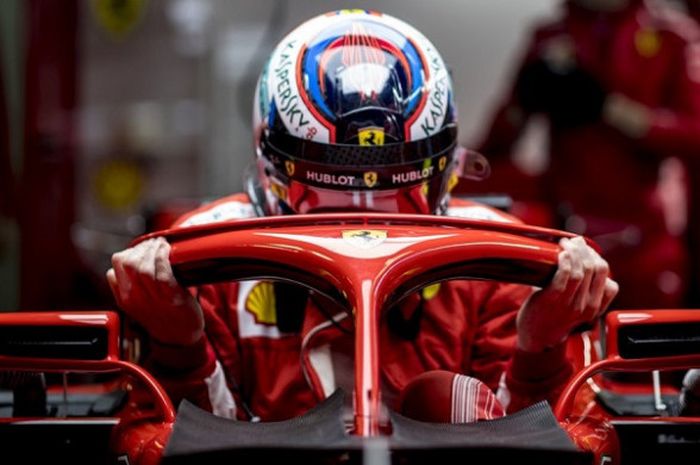  Pebalap Ferrari, Kimi Raikkonen, saat bersiap memasuki mobilnya dalam sesi tes pramusim F1 yang berlangsung di Circuit de Catalunya, Barcelona, Senin (26/2/2018). 