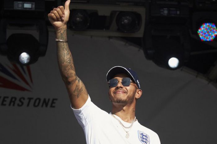  Lewis Hamilton tampil dengan menggunakan jersey timnas Inggris saat menghadiri acara yang digelar seusai sesi kualifikasi di Sirkuti Silverstone berakhir, Sabtu (8/7/2018). 