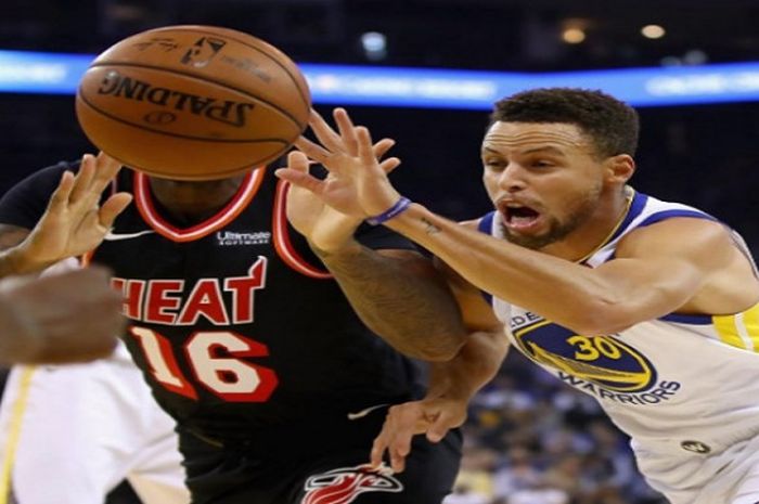 Pemain Warriors, Stephen Curry (kanan) saat berebut bola dengan pemain Miami Heat dalam laga lanjutan NBA 2017/18, Senin (6/11/2017) waktu Amerika Serikat.