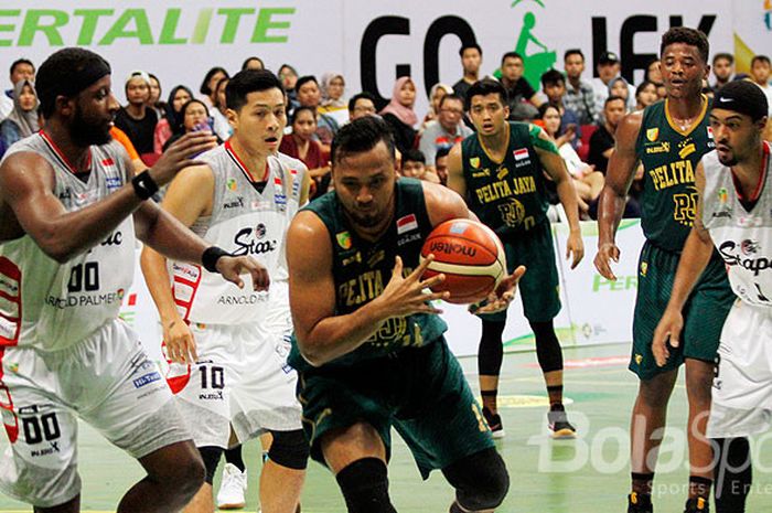 Pebasket Pelita Jaya, Adhi Prasetyo Putra (tengah), berupaya menguasai bola dikawan ketat pemain Stapac Jakarta, dalam laga pamungkas Seri VI Indonesia Basketball (IBL) di GOR UNY, Yogyakarta, Minggu (28/1/2018).