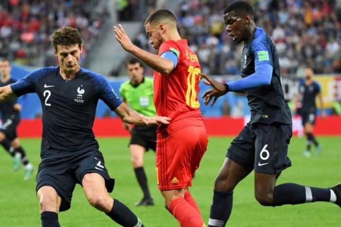 Eden Hazard (tengah) berusaha melewati Benjamin Pavard (kiri) dan Paul Pogba dalam partai semifinal Piala Dunia 2018 antara Prancis vs Belgia di Saint Petersburg Stadium, 10 Juli 2018.  