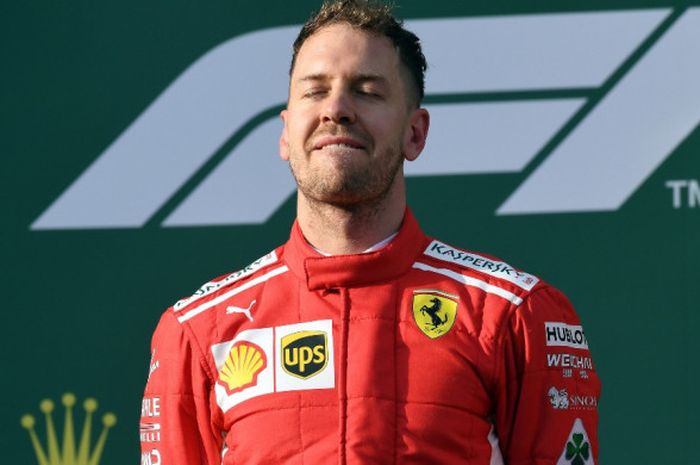 Pebalap Ferrari, Sebastian Vettel, memenjamkan mata untuk menikmati momen kemenangannya pada GP Australia yang menjadi seri pembuka Formula 1 (F1) 2018. Vettel tampil sebagai kampiun pada balapan di Melbourne, Minggu (25/3/2018). 