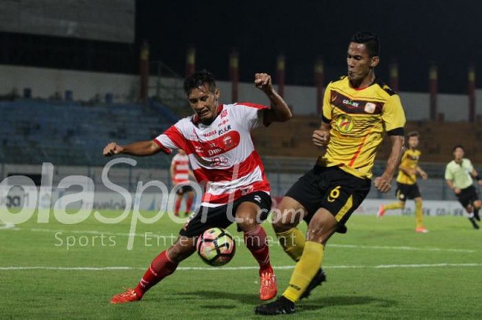 Pemain Madura United, Guntur Ariyadi, berduel dengan pemain Barito Putera, Ambrizal, pada lanjutan laga Liga 1, Minggu (5/11/2017).