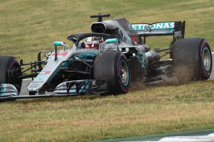 Pebalap Mercedes, Lewis Hamilton, menerobos rerumputan untuk kembali masuk ke trek balapan setelah batal melakukan pitstop saat balapan GP Jerman di Sirkuit Hockenheimring, Minggu (22/7/2018).