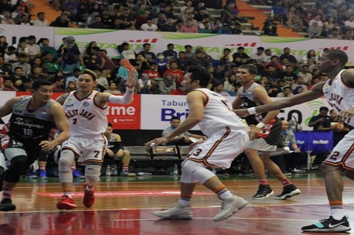 Pemain Stapac, Fandi Andika Ramadhani (jersey hitam #12) saat berusaha menembus pertahanan Pelita Jaya dalam lanjutan laga IBL 2017/2018 seri Solo, Senin (26/12/2017).