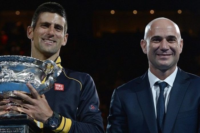 Petenis asal Serbia, Novak Djokovic (kiri), berpose sambil mengangkat trofi Australia Terbuka bersama eks petenis asal Amerika Serikat, Andre Agassi, di Melbourne, Australia, 27 Januari 2013. 