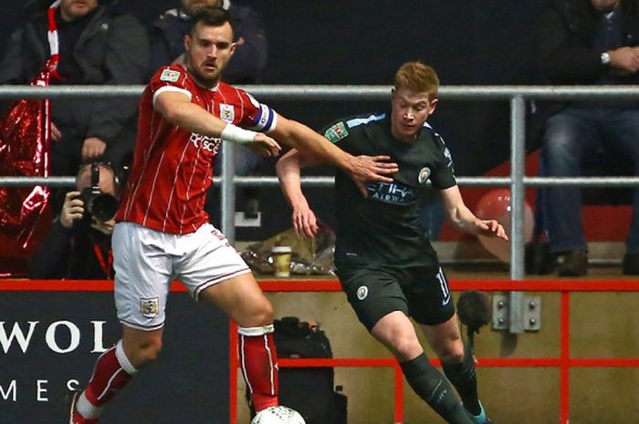 Gelandang Manchester City, Kevin De Bruyne (kanan), berduel dengan bek Bristol City, Bailey Wright, dalam laga leg kedua semifinal Piala Liga Inggris di Stadion Ashton Gate, Bristol, pada 23 Januari 2018.