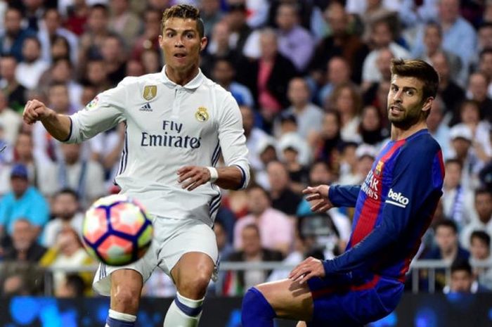 Cristiano Ronaldo (kiri) dan Gerard Pique berduel dalam partai Liga Spanyol antara Real Madrid dan Barcelona di Santiago Bernabeu, Madrid, 23 April 2017.