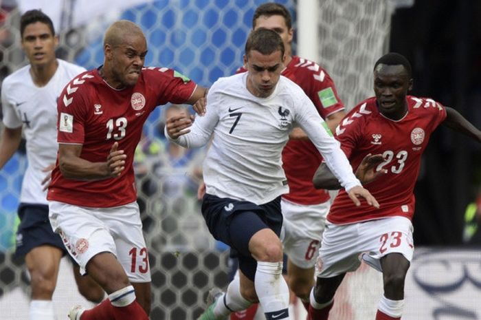 Penyerang Prancis, Antoine Griezmann (tengah), berduel dengan bek Denmark, Mathias Jorgensen, dalam laga Grup C Piala Dunia 2018 di Luzhniki Stadium, Moskow, Rusia pada 26 Juni 2018.