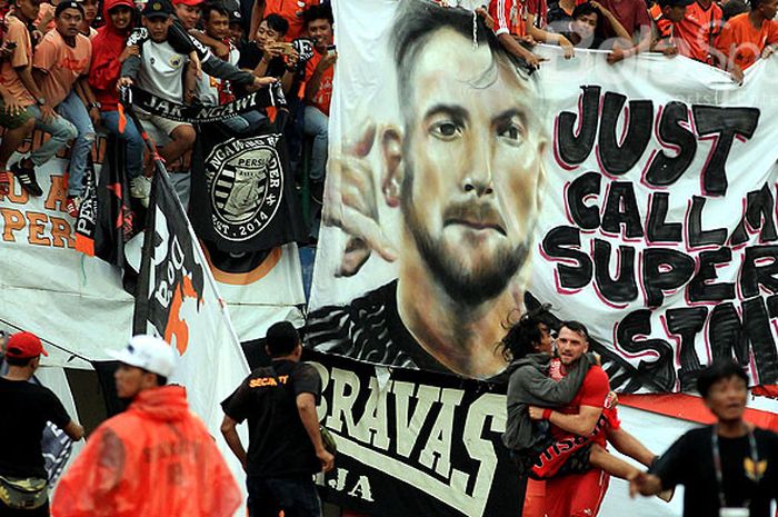 Pendukung Persija Jakarta, Jakmania, membentangkan poster potret striker Persija Jakarta, Marko Simic, yang sedang menggendong salah seorang pendukung usai merayakan gol pada babak delapan besar Piala Presiden 2018 melawan Mitra Kukar di Stadion Manahan, Solo, Minggu (4/2/2018).