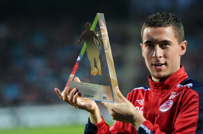 Eden Hazard memegang trofi penghargaan sebagai pemain terbaik Ligue 1 di pertandingan Lille melawan Bourdeaux pada 16 April di Stadion Lille Metropole. 