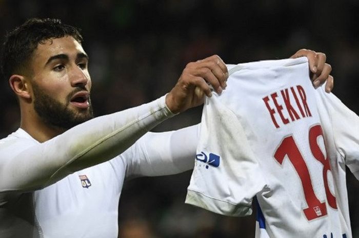 Striker Olympique Lyonnais, Nabil Fekir, berselebrasi membentangkan jersey di hadapan suporter Saint-Etienne, Minggu (5/11/2017).