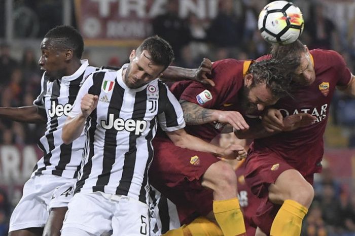 Gelandang Juventus, Blaise Matuidi (kiri) dan Miralem Pjanic (kedua dari kiri) berduel memperebutkan bola dengan pemain AS Roma, Daniele De Rossi (kedua dari kanan) dan Edin Dzeko (kanan), dalam laga Liga Italia 2017-2018 di Stadio Olimpico, Roma, Italia, pada Minggu (13/5/2018).