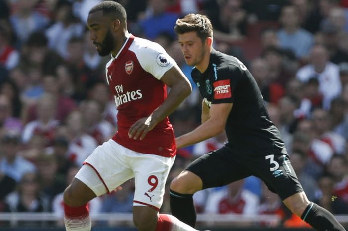 Striker Arsenal, Alexandre Lacazette (kiri), saat berusaha menggiring bola dalam pengawasan bek West Ham United, Aaron Cresswell, dalam laga Liga Inggris 2017-2018 di Stadion Emirates, London, Inggris, pada Minggu (22/4/2018).