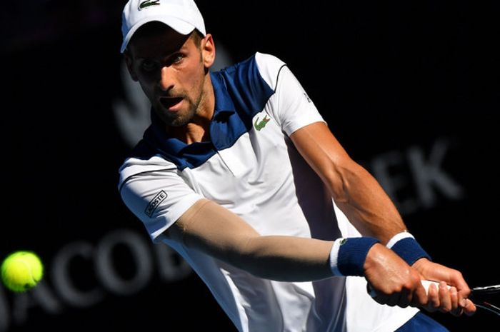 Petenis tunggal putra Serbia, Novak Djokovic, mengembalikan bola yang dipukul sang lawan, Gael Monfils (Prancis), pada babak kedua turnamen Australia Terbuka 2018 di Rod Laver Arena, Melbourne Park, Kamis (18/1/2018).