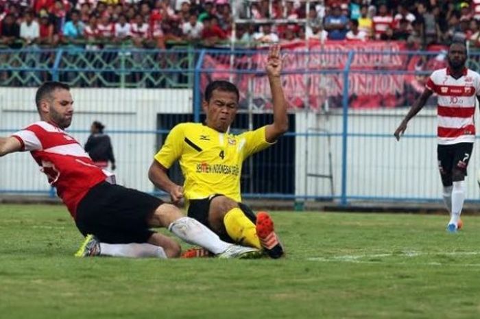  Saepulloh Maulana (kuning) saat berseragam Semen Padang menjalani uji coba timnya kontra Madura United pada uji coba di Stadion Gelora Bangkalan, 7 April 2016. 