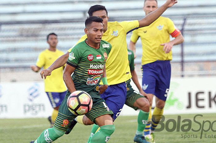 Gelandang PS TNI, Erwin Ramdani (hijau) mencoba lepas dari kawalan pemain Persegres pada laga di stadion Surajaya Lamongan, Sabtu (28/10/2017).