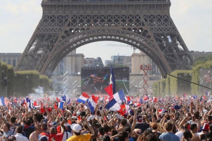  Kemeriahan suporter timnas Prancis di fan zone Champ de Mars, Paris, merayakan kesuksesan negara mereka menjuarai Piala Dunia 2018 usai menekuk Kroasia dalam laga final Piala Dunia 2018 di Stadion Luzhniki, Moskow, 15 Juli 2018. 