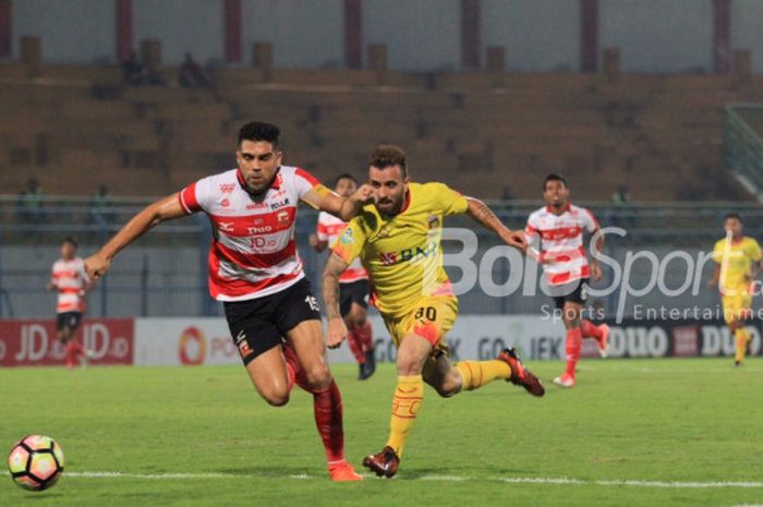 Bek Madura United Fabiano Beltrame (kiri) coba mengejar penyerang Bhayangkara FC Ilija Spasojevic pada pertandingan Liga 1, Rabu (8/11/2017) malam WIB, di Stadion Gelora Bangkalan, Bangkalan, Jawa Timur. 