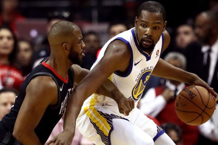 Pemain Golden State Warriors, Kevin Durant (kanan), saat berusaha melewati hadangan penjagaan pemain Houston Rockets, Chris Paul, pada laga final wilayah barat NBA 2017/18, Senin (14/5/2018) waktu Amerika Serikat.