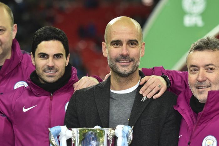 Manajer Manchester City, Pep Guardiola (kedua dari kanan), berfoto bersama asistennya, Domenec Torrent (kanan), Rodolpho Borrell (kiri), dan Mikel Arteta saat merayakan keberhasilan mereka menjuarai Piala Piga Inggris setelah mengalahkan Arsenal di Stadion Wembley, London, Inggris, pada 25 Februari 2018.