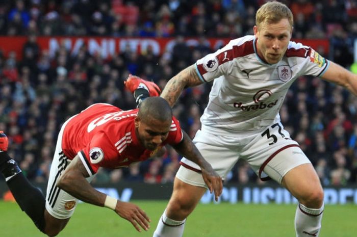 Ashley Young (kiri) tersungkur saat berduel dengan Scott Arfield dalam partai Liga Inggris Manchester United vs Burnley di Old Trafford, 26 Desember 2017.