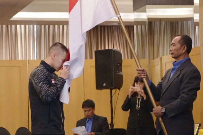  Marcus Fernaldi Gideon sedang mencium bendera Indonesia pada acara pelepasan tim Piala Thomas dan Uber di Hotel Atlet Century, Jakarta, Selasa (8/5/2018). 