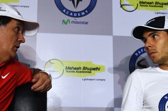 Petenis Spanyol, Rafael Nadal (kanan), berbicara dengan pelatihnya, Toni Nadal, pada konferensi pers pembukaan akademi tenis di New Delhi, India, 10 Desember 2015.