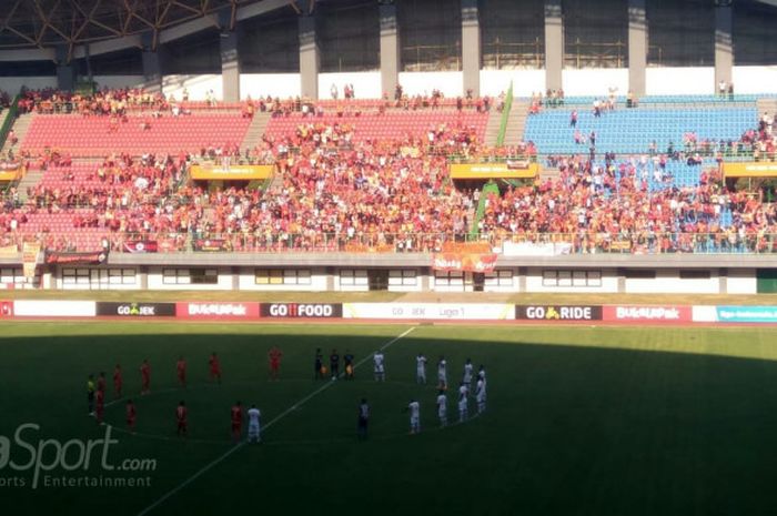 Pemain Persija Jakarta dan Perseru Serui membentuk lingkaran saat prosesi mengheningkan cipta untuk almarhum Haringga Sirila dan korban gempa serta tsunami Sulawesi Tengah, di Stadion Patriot Chandrabhaga, Bekasi, Senin (8/10/2018).