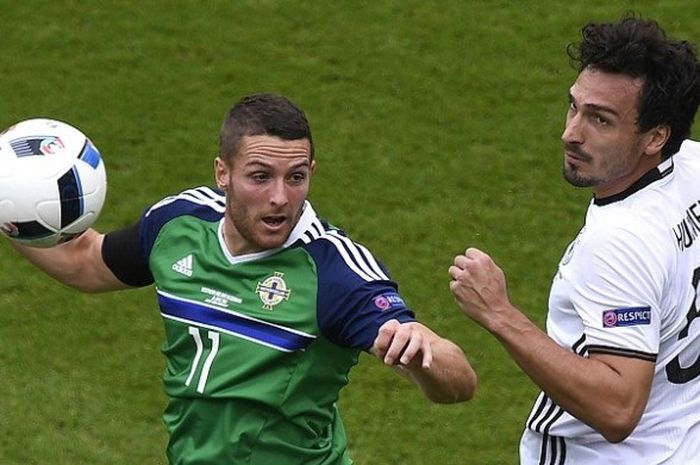 Bek Jerman, Mats Hummels (kanan), berduel memperebutkan bola dengan penyerang Irlandia Utara, Conor Washington, dalam laga pamungkas Grup C Piala Eropa 2016 di Parc des Princes, Paris, Selasa (21/6/2016) waktu setempat.