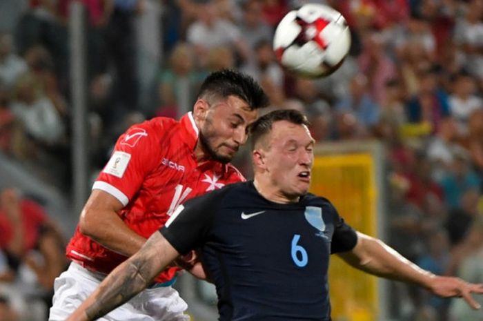 Bek timnas Inggris, Phil Jones, berduel dengan pemain Malta, Jean Paul Farrugia di pertandingan kualifikasi Piala Dunia 2018 di National Stadium pada 1 September 2017.