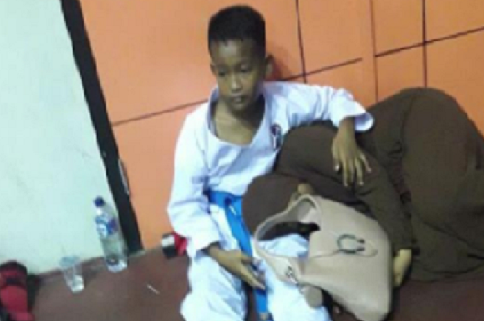 Seorang Karateka cilik memeluk ibunya yang sedang tertidur