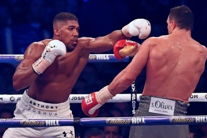 Petinju Inggris, Anthony Joshua (kiri), melancarkan pukulan ke arah petinju asal Ukraina, Wladimir Klistchko, dalam pertarungan kelas berat di Stadion Wembley, London, Sabtu (29/4/2017) waktu setempat.