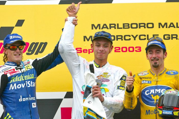 Valentino Rossi (tengah) merayakan keberhasilannya menjadi juara MotoGP musim 2003 setelah naik ke podium GP Malaysia bersama Sete Gibernau (kiri) dan Max Biaggi (12/10/2003).