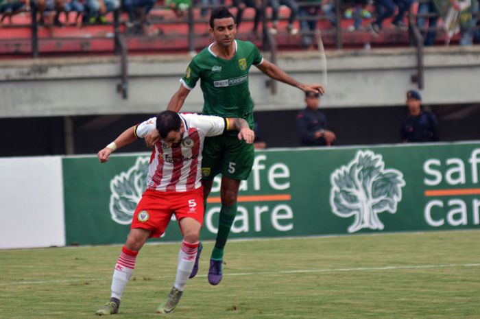 Duel dua bek antara Otavio Dutra dari Persebaya dengan Milos Raikovic dari Sarawak FA pada laga uji coba internasional di Gelora Bung Tomo, Kota Surabaya, Minggu (18/3/2018). 