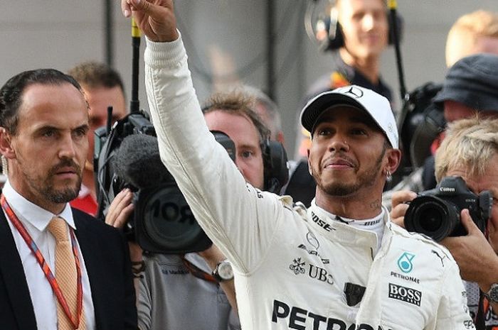 Pebalap Mercedes, Lewis Hamilton, melambaikan tangannya ke arah penonton setelah menjadi yang tercepat pada sesi kualifikasi GP Malaysia, di Sirkuit Sepang, Sabtu (30/9/2017).