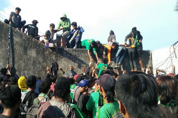 Oknum suporter bahu-membahu melompati tembon sisi selatan Stadion Sultang Agung di Kabupaten Bantul saat PS Tira menjamu Persebaya, Jumat (13/4/2018). 