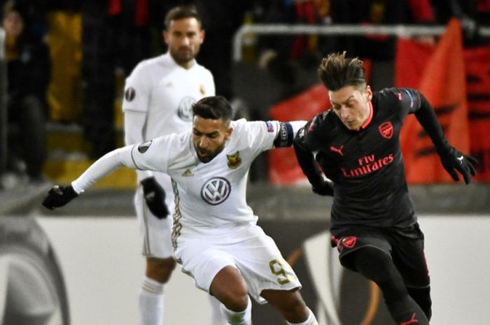 Gelandang Arsenal, Mesut Oezil (kanan), berduel dengan pemain Oestersunds FK, Saman Ghoddos, dalam laga leg pertama babak 32 besar Liga Europa di Stadion Oestersund Arena, Oestersund, Swedia, pada 15 Februari 2018.