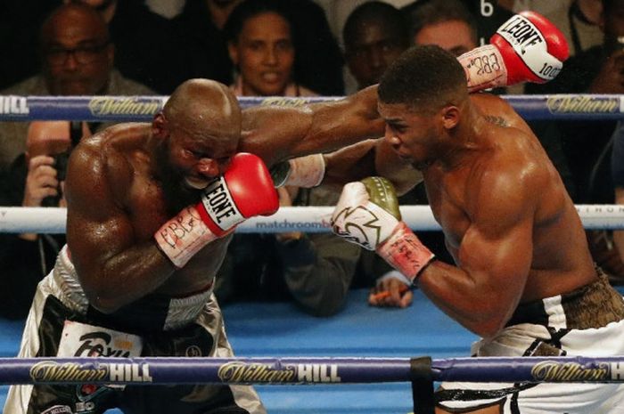 Petinju kelas berat Inggris, Anthony Joshua (kanan), dan Carlos Takam (Prancis), saling melayangkan pukulan pada duel perebutan gelar juara dunia di Principality Stadium, Cardiff, Wales, Sabtu (28/10/2017). Joshua dinyatakan menang TKO atas Takam pada ronde ke-10.