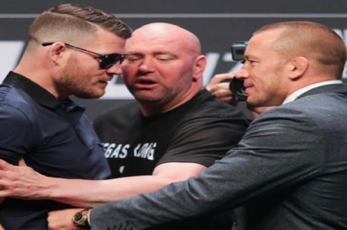 Michael Bisping (kiri) dan Georges St-Pierre (kanan) ditengahi oleh presiden UFC, Dana White, menjelang ajang UFC 217.