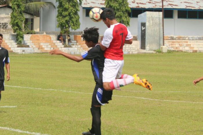 Pertarungan di udara antara pemain Binjai United (merah) dan pemain Kurnia FC.