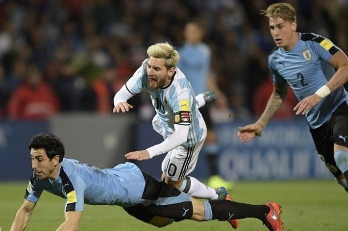 Kapten Argentina, Lionel Messi (tengah), berduel dengan bek Uruguay, Jorge Fucile (kiri bawah), dalam laga kualifikasi Piala Dunia 2018 zona Amerika Selatan, di Estadio Malvinas Argentinas, Argentina, Kamis (1/9/2016) atau Jumat pagi WIB.