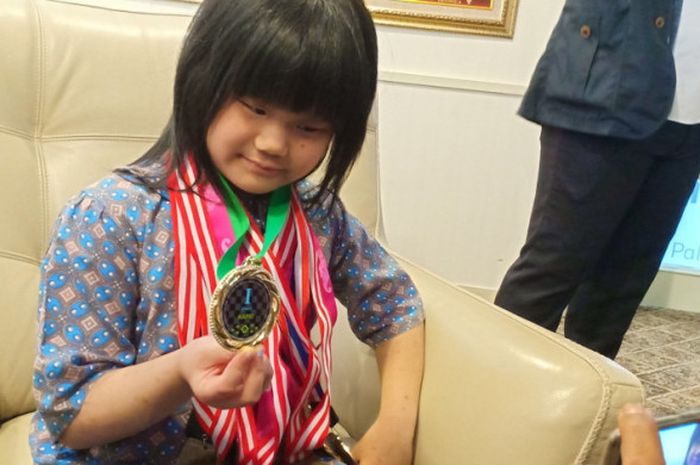 Pecatur junior Indonesia, Samantha Edithso, berpose dengan medali juara dunia yang ia raih pada ajang FIDE World Championship 2018 U-10 di sela-sela acara pemberian penghargaan dari Menteri Pemuda dan Olahraga, Imam Nahrawi, di Kantor Kemenpora, Jakarta Pusat, pada Senin (23/7/2018).