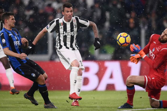 Aksi striker Juventus, Mario Mandzukic (tengah), saat melepaskan tembakan ke arah kiper Atalanta, Etrit Berisha (kanan), dalam laga leg 2 babak semifinal Coppa Italia 2017-2018 di Juventus Stadium, Turin, Italia, pada Rabu (28/2/2018).