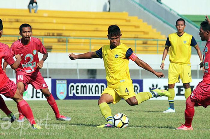 Kapten Persegres Gresik United, Wismoyo Yudistio (kuning), berupaya melepaskan tembakan di tengah kepungan pemain Martapura FC pada laga lanjutan Liga 2 2018 di Stadion Demang Lehman Martapura, Senin (6/8/2018).