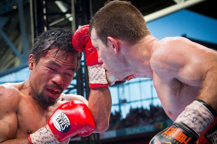 Petinju Filipina, Manny Pacquiao (kiri), berupaya menepis pukulan dari Jeff Horn, pada laga yang digelar di Suncorp Stadium, Brisbane, Australia, 2 Juli 2017.