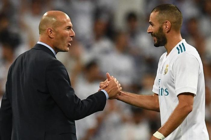 Pelatih Real Madrid, Zinedine Zidane (kiri), bersalaman dengan Karim Benzema setelah memenangi laga Piala Super Spanyol lawan Barcelona di Santiago Bernabeu, 16 Agustus 2017.