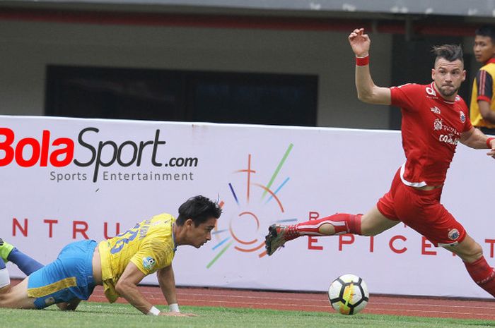  Bek Barito Putera, Gavin Kwan Adsit terjatuh saat mengejar striker Persija, Marko Simic pada lanjutan Liga 1 2018 di Stadion Patriot, Kota Bekasi, 30 Oktober 2018.  