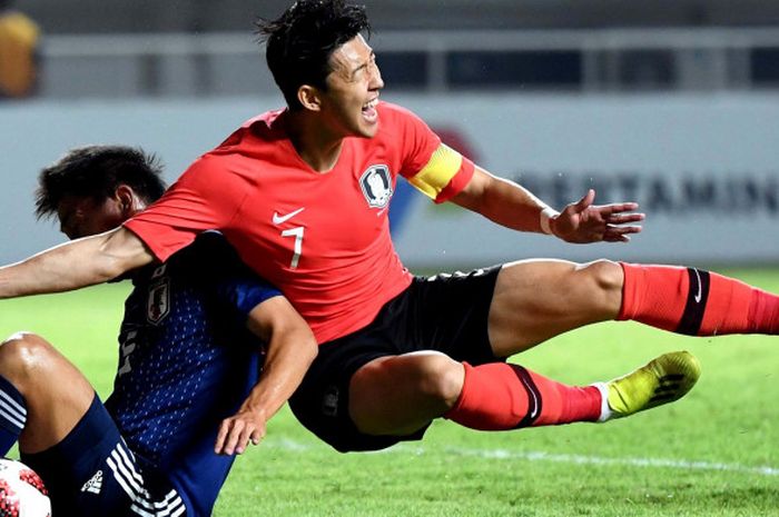 Pesepak bola Korea Selatan Heung Min Son (kanan)  berebut bola dengan pesepak bola Jepang Daiki Sugioka  pada Babak Putra Pertandingan Medali Emas Asian Games 2018 di Stadion Pakan Sari,Bogor, Jawa Barat, Sabtu (1/9/2018).  